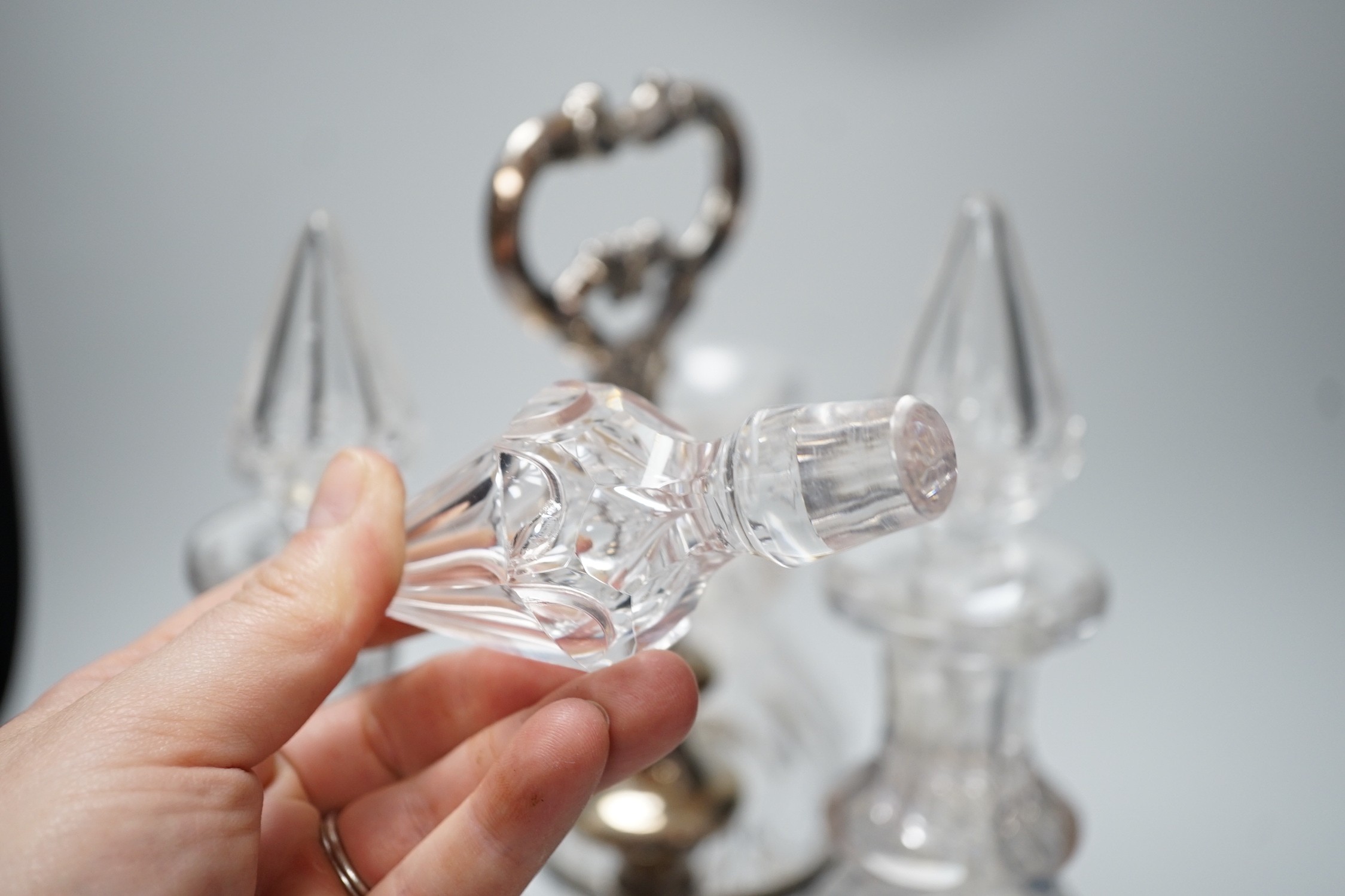 A decorative three bottle decanter set, on lion feet tripod plated stand. 37cm tall